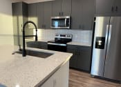 Thumbnail 51 of 88 - a kitchen with granite counter tops and stainless steel appliances at The Depot, Raymore