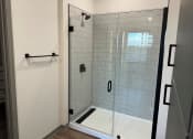 Thumbnail 53 of 88 - a white tiled shower in a bathroom with a glass door at The Depot, Missouri, 64083