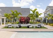 Thumbnail 24 of 58 - a yard with a pool and furniture in front of a house at Palm Grove in Ellenton, FL 34222