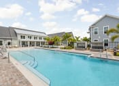 Thumbnail 22 of 58 - a large swimming pool in front of a building at Palm Grove in Ellenton, FL 34222