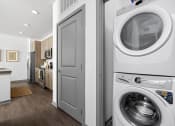 Thumbnail 9 of 58 - a white washer and dryer in a white laundry room with a white door at Palm Grove in Ellenton, FL 34222