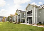 Thumbnail 45 of 58 - a row of houses with grass and palm trees in front of them at Palm Grove in Ellenton, FL 34222