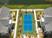 Thumbnail 35 of 58 - an aerial view of a tennis court with a player on the court at Palm Grove in Ellenton, FL 34222