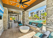 Thumbnail 18 of 60 - A patio with a white table and blue cushions.