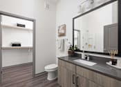 Thumbnail 29 of 60 - A bathroom with a toilet, sink, and mirror.