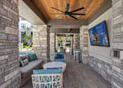 Thumbnail 44 of 60 - A patio with a ceiling fan and a couch.