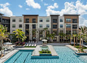 Thumbnail 46 of 60 - A large building with a pool in front of it.