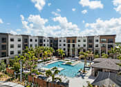 Thumbnail 10 of 60 - A large swimming pool is surrounded by apartment buildings.