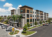 Thumbnail 3 of 60 - A row of modern apartment buildings with a parking lot in front.