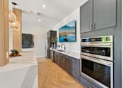 Thumbnail 48 of 60 - A modern kitchen with a large island and stainless steel appliances.