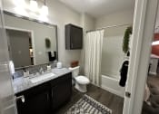 Thumbnail 44 of 56 - a bathroom with a shower toilet and sink and a mirror at Watermark at Steele Crossing, Fayetteville, 72703