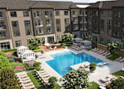 Thumbnail 2 of 4 - A large swimming pool surrounded by lounge chairs and umbrellas in the middle of a courtyard.