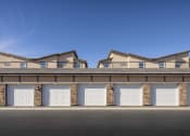 Thumbnail 56 of 68 - a building with several garages with white doors at Grandstone at Sunrise, Peoria, AZ