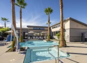 Thumbnail 40 of 68 - a swimming pool in front of a building with palm trees at Grandstone at Sunrise, Peoria, AZ
