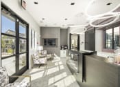 Thumbnail 66 of 68 - a lobby with a reception desk and chairs and sliding glass doors at Grandstone at Sunrise, Peoria, AZ