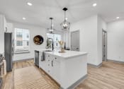 Thumbnail 26 of 58 - a white kitchen with a large island in the middle at Meridian at CityPlace, Woodbury