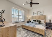 Thumbnail 5 of 46 - a bedroom with a bed and a ceiling fan at Alta25, Monument, Colorado