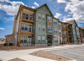 Thumbnail 2 of 46 - an exterior view of the apartment building with a parking lot at Alta25, Monument, 80132