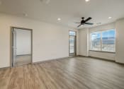 Thumbnail 36 of 46 - an empty living room with a ceiling fan and a window at Alta25, Monument, Colorado