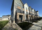 Thumbnail 41 of 45 - an exterior view of a row of apartments with a sidewalk and grass at The BLVD at Wilson Crossings, Wyoming, MI