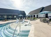 Thumbnail 9 of 45 - a swimming pool with chairs and umbrellas outside of a building at The BLVD at Wilson Crossings, Wyoming