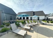 Thumbnail 8 of 45 - a patio with chairs and umbrellas in front of a building at The BLVD at Wilson Crossings, Wyoming Michigan