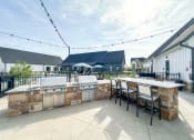 Thumbnail 7 of 45 - spacious outdoor patio with grill and bar and seating at The BLVD at Wilson Crossings, Wyoming, MI