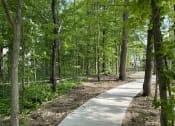 Thumbnail 44 of 45 - a walking path through the woods in a park at The BLVD at Wilson Crossings, Wyoming, MI 49418