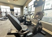 Thumbnail 32 of 56 - a gym with cardio equipment and windows in a building at Watermark at Steele Crossing, Fayetteville, 72703