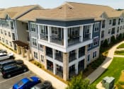 Thumbnail 5 of 56 - an aerial view of an apartment building with cars parked in a parking lot at Watermark at Steele Crossing, Arkansas, 72703