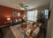 Thumbnail 35 of 56 - a living room with red walls and a ceiling fan at Watermark at Steele Crossing, Fayetteville, AR