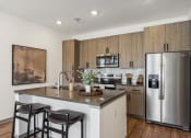 Thumbnail 17 of 40 - a kitchen with stainless steel appliances and a island with two chairs at Stella, San Tan Valley Arizona