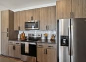 Thumbnail 24 of 40 - a kitchen with stainless steel appliances and wooden cabinets at Stella, San Tan Valley, AZ 85143