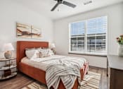 Thumbnail 2 of 11 - A bedroom with a bed, a ceiling fan, and a painting on the wall at The Pullman Luxury Apartment Homes, Georgia 30349