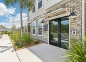 Thumbnail 43 of 49 - the front of the building with glass doors and a sidewalk at Drift, Daytona Beach, FL, 32117