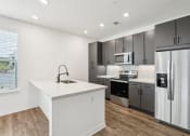 Thumbnail 9 of 49 - a kitchen with stainless steel appliances and a white counter top at Drift, Daytona Beach, FL, 32117