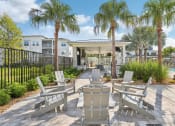 Thumbnail 34 of 49 - an outdoor patio with chairs and palm trees at Drift, Daytona Beach, FL, 32117