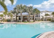 Thumbnail 36 of 49 - a large swimming pool with palm trees in front of a building at Drift, Daytona Beach, FL, 32117