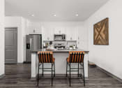 Thumbnail 11 of 56 - a kitchen with a bar and stools and a stainless steel refrigerator at Notch66, Longmont, Colorado