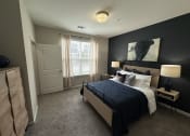 Thumbnail 43 of 56 - a master bedroom with a large bed and a black accent wall at Watermark at Steele Crossing, Fayetteville, Arkansas