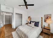 Thumbnail 29 of 45 - a bedroom with a bed and a ceiling fan at The BLVD at Wilson Crossings, Wyoming, MI