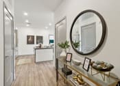 Thumbnail 68 of 88 - a living room with an oval mirror and a glass display case at The Depot in The Depot Raymore, MO 64083