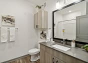 Thumbnail 86 of 88 - a bathroom with a mirror and a toilet and a sink at The Depot in The Depot Raymore, MO 64083