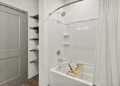 Thumbnail 31 of 88 - a bathroom with a shower and a tub and a closet at The Depot in The Depot Raymore, MO 64083