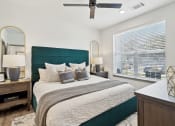 Thumbnail 72 of 88 - a bedroom with a large bed and a ceiling fan at The Depot in The Depot Raymore, MO 64083