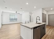 Thumbnail 83 of 88 - a white kitchen with a large counter top and a sink at The Depot in The Depot Raymore, MO 64083