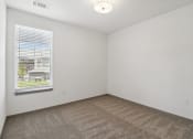 Thumbnail 78 of 88 - the living room of an apartment with carpet and a window at The Depot in The Depot Raymore, MO 64083