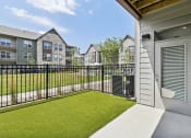 Thumbnail 25 of 88 - the yard of a condo with a green lawn and a fence at The Depot Raymore, MO 64083