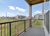 Thumbnail 6 of 88 - the view from the balcony of an apartment building with a flag on the balcony railing atThe Depot Raymore, MO 64083