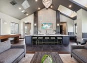 Thumbnail 15 of 88 - a clubhouse with a bar and a living room with couches at The Depot in The Depot Raymore, MO 64083